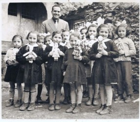 Una ridente scolaresca che mostra delle bamoline di pezza